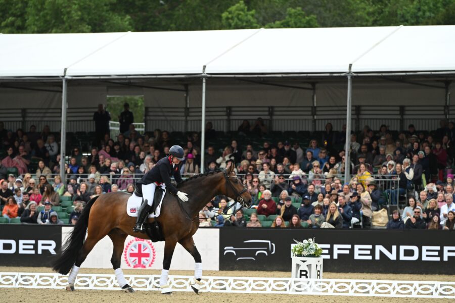 lady riding dressage in front of crowd in windsor