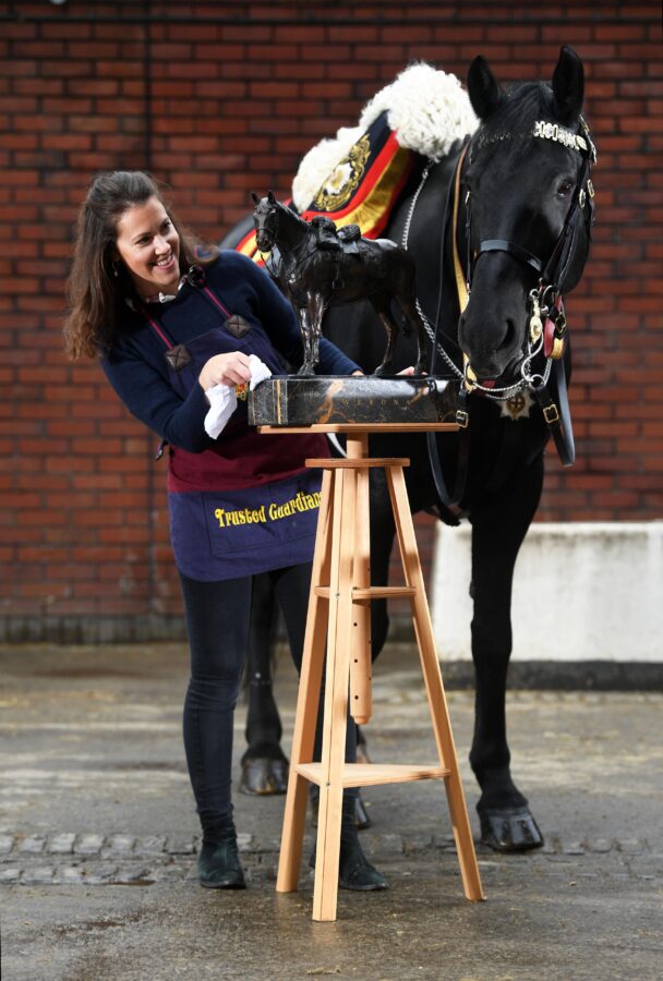 zoe holding her sculpture in front of horse